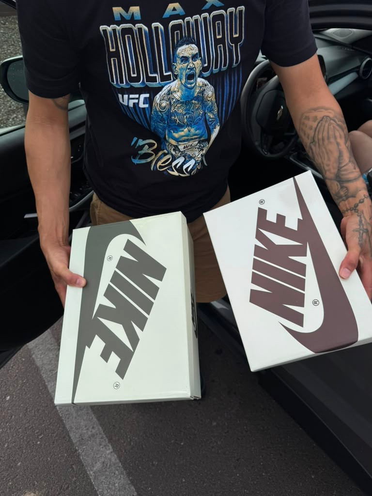 Customer holding two fresh Nike boxes after delivery