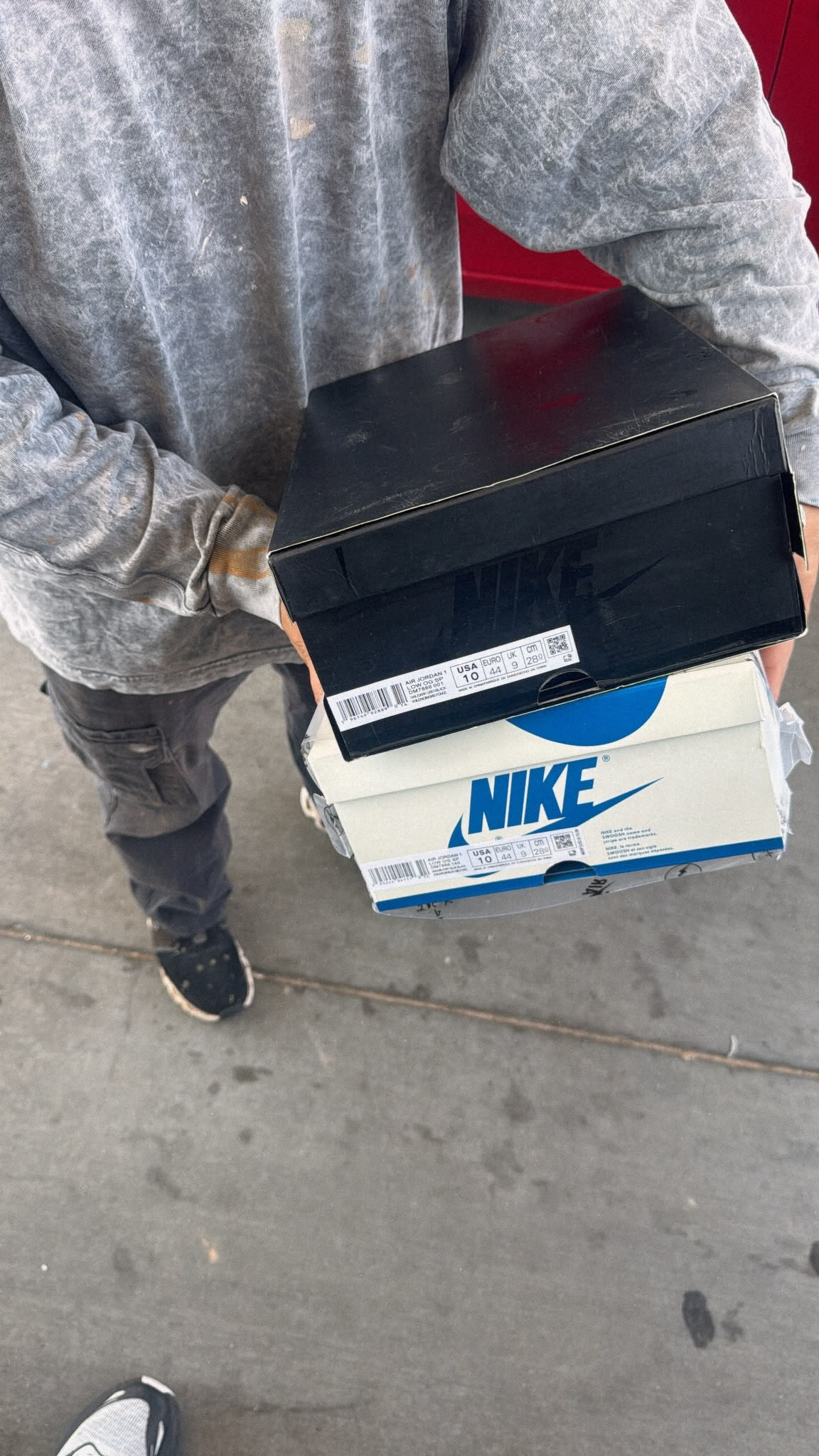 Two sneaker orders delivered stacked in hand by customer