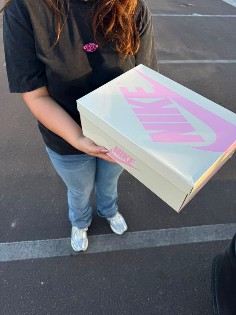 Female customer holding white Nike box after order delivery